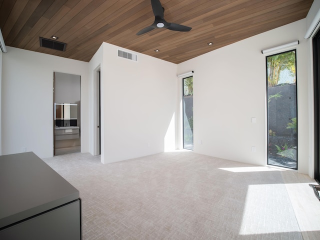 carpeted spare room with ceiling fan and wood ceiling