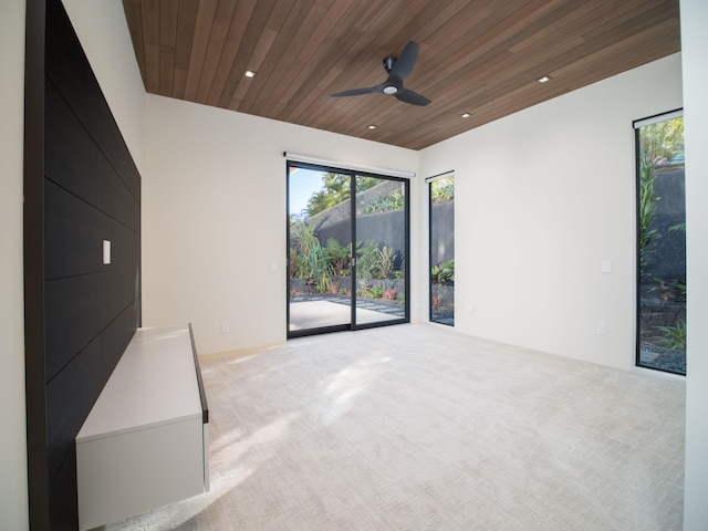 carpeted empty room with ceiling fan and wooden ceiling