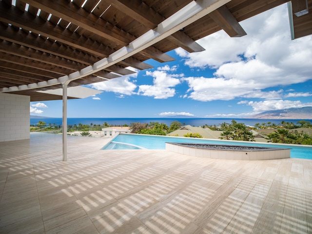 view of pool with a water view and a patio area