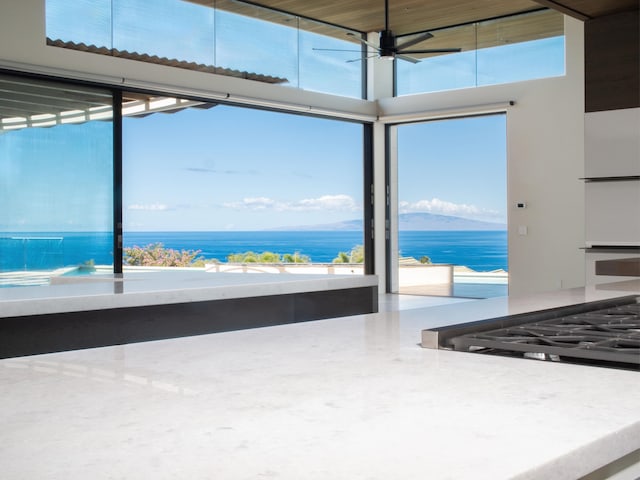 kitchen with white oven, a high ceiling, ceiling fan, and a water view