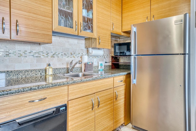 kitchen with dark stone countertops, black appliances, tasteful backsplash, and sink