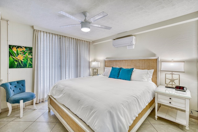 tiled bedroom with an AC wall unit, ceiling fan, and a textured ceiling