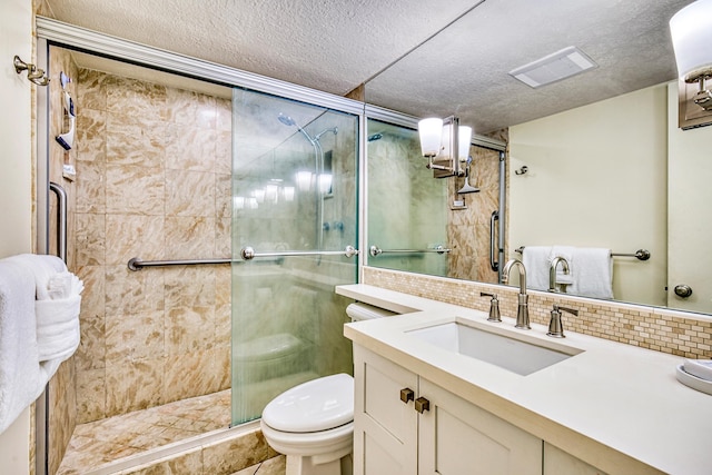 bathroom featuring vanity, a textured ceiling, an enclosed shower, and toilet