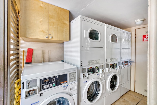 laundry room with washer and clothes dryer, light tile patterned flooring, and stacked washer and dryer