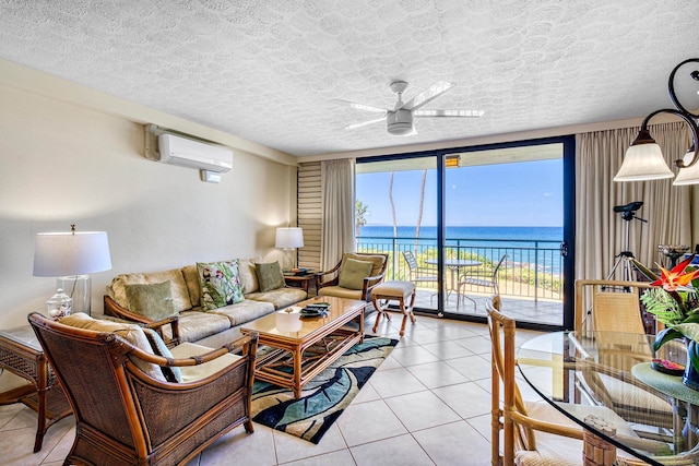 tiled living room featuring a water view, a textured ceiling, ceiling fan, and a wall mounted AC