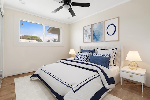 bedroom with baseboards, light wood-type flooring, ceiling fan, and ornamental molding