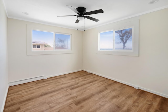 spare room with a wealth of natural light, a baseboard heating unit, light wood-type flooring, and ornamental molding
