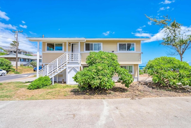 view of front of home featuring covered porch and stairs
