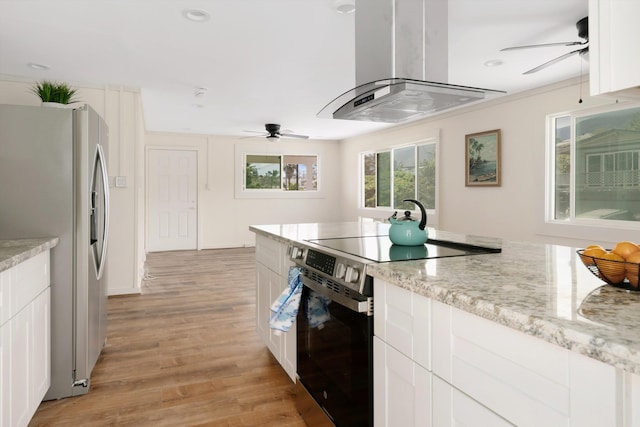 kitchen featuring stainless steel appliances, light wood-style floors, island range hood, and a ceiling fan