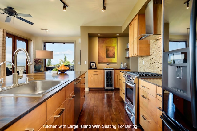 kitchen featuring wall chimney range hood, sink, dark hardwood / wood-style floors, stainless steel appliances, and beverage cooler