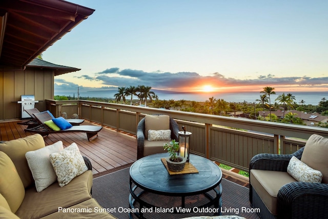 deck at dusk with area for grilling and a water view