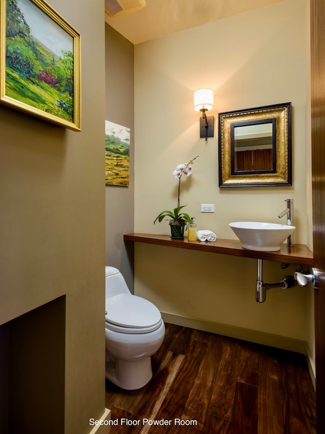 bathroom with hardwood / wood-style flooring, toilet, and sink