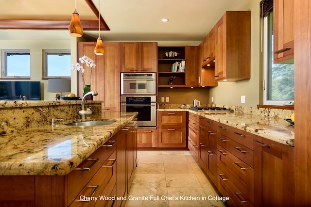 kitchen with light stone countertops, hanging light fixtures, a healthy amount of sunlight, and sink