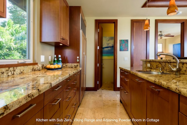 kitchen with a wealth of natural light, sink, ceiling fan, and pendant lighting