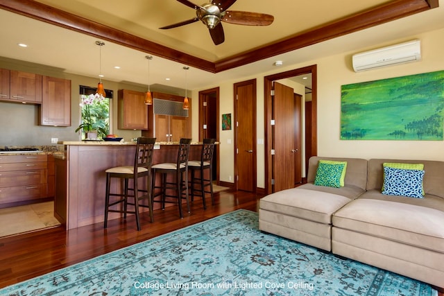 living room featuring dark hardwood / wood-style floors, ceiling fan, an AC wall unit, and ornamental molding