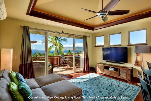 living room featuring hardwood / wood-style floors, ceiling fan, a raised ceiling, and a wall mounted AC