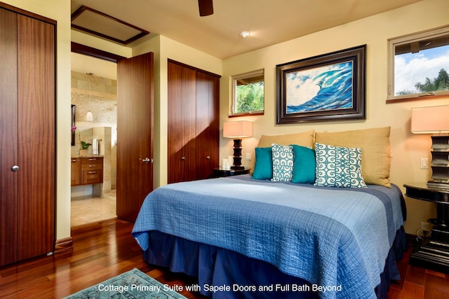 bedroom with connected bathroom, ceiling fan, dark hardwood / wood-style flooring, and multiple closets