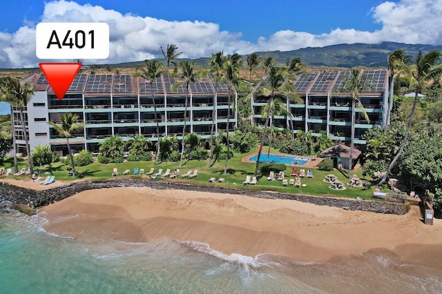 view of building exterior with a view of the beach and a water and mountain view