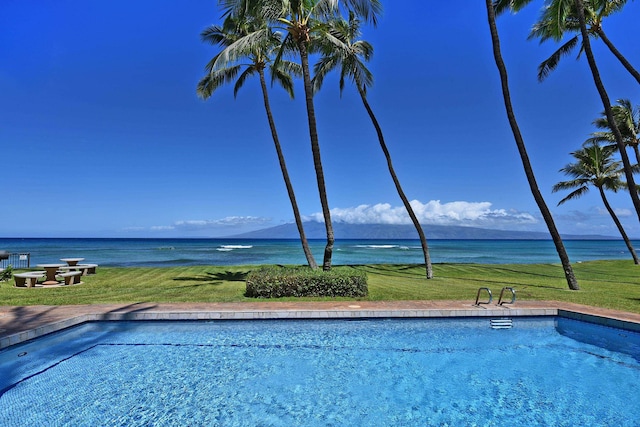 view of pool featuring a yard and a water view