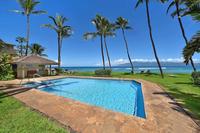 view of pool featuring a water view and a yard