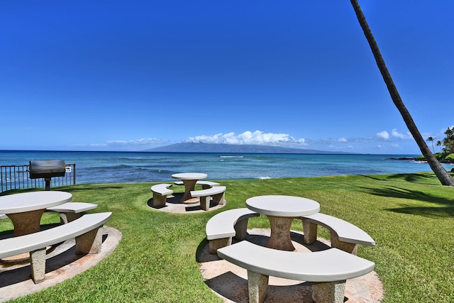 exterior space with a lawn and a water and mountain view