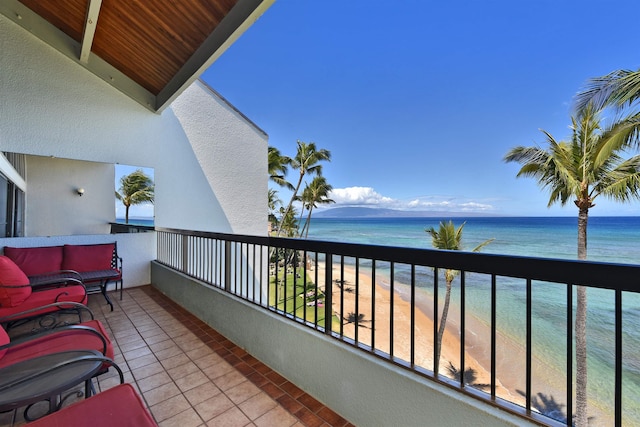 balcony featuring a view of the beach and a water view