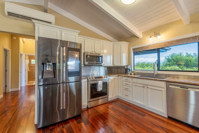 kitchen featuring sink, white cabinetry, backsplash, a wall mounted air conditioner, and appliances with stainless steel finishes