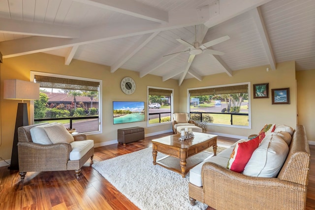 living room with ceiling fan, beamed ceiling, plenty of natural light, and hardwood / wood-style flooring