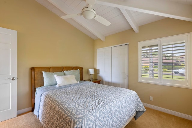 bedroom with lofted ceiling with beams, a closet, ceiling fan, and light colored carpet