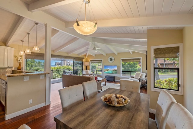 dining room featuring ceiling fan, dark hardwood / wood-style flooring, and vaulted ceiling with beams