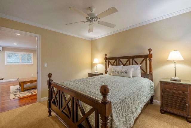 carpeted bedroom featuring ceiling fan and crown molding