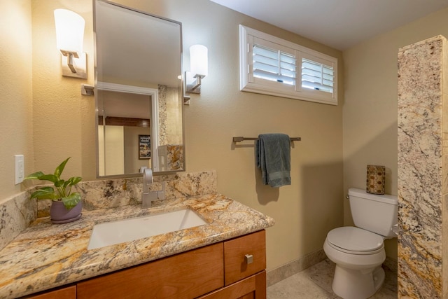 bathroom featuring tile patterned floors, vanity, and toilet