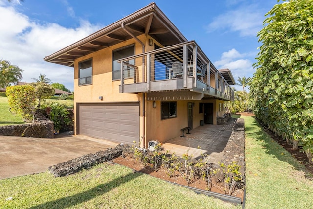 exterior space with a lawn, a balcony, and a garage