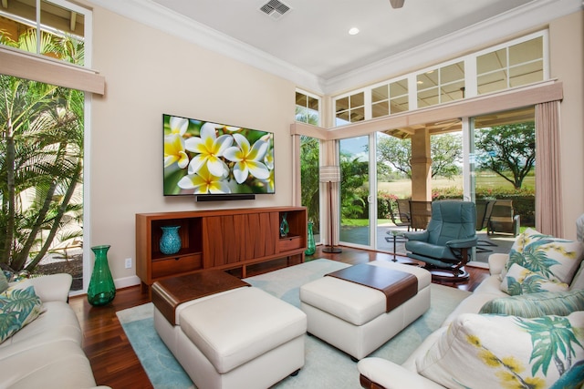 living room featuring recessed lighting, wood finished floors, visible vents, baseboards, and ornamental molding