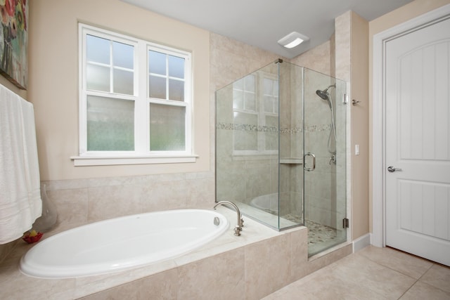 bathroom featuring a stall shower, a bath, and tile patterned floors