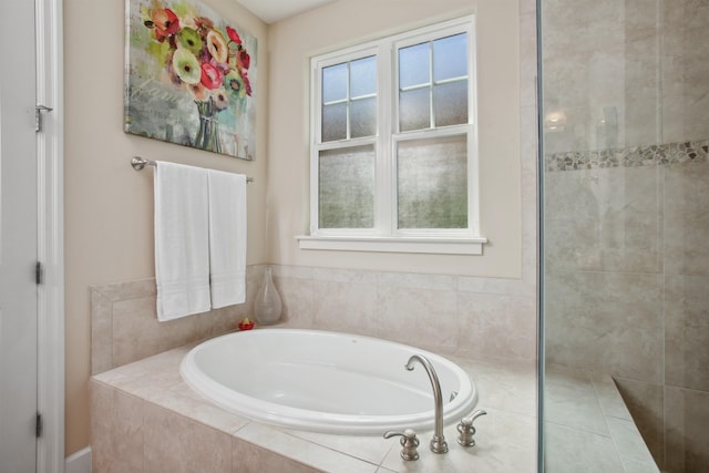 bathroom with tiled shower and a bath