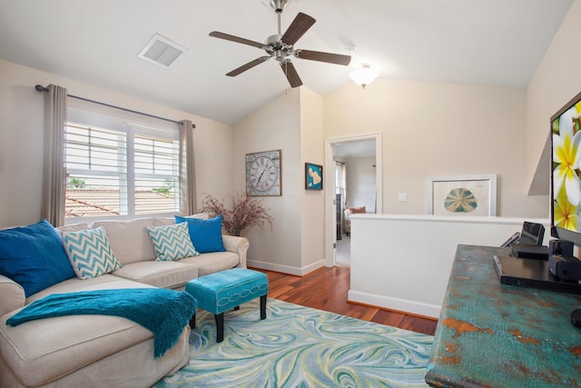 living area with baseboards, visible vents, a ceiling fan, wood finished floors, and vaulted ceiling