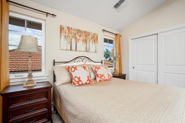 bedroom with a closet, visible vents, and vaulted ceiling