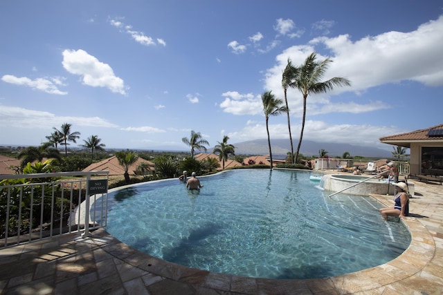 community pool with a patio area and an in ground hot tub