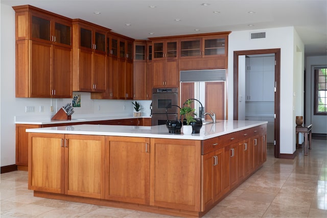 3002 S Kihei Rd, Kihei, HI 96753 - kitchen with paneled built in fridge, double oven, light countertops, glass insert cabinets, and a large island
