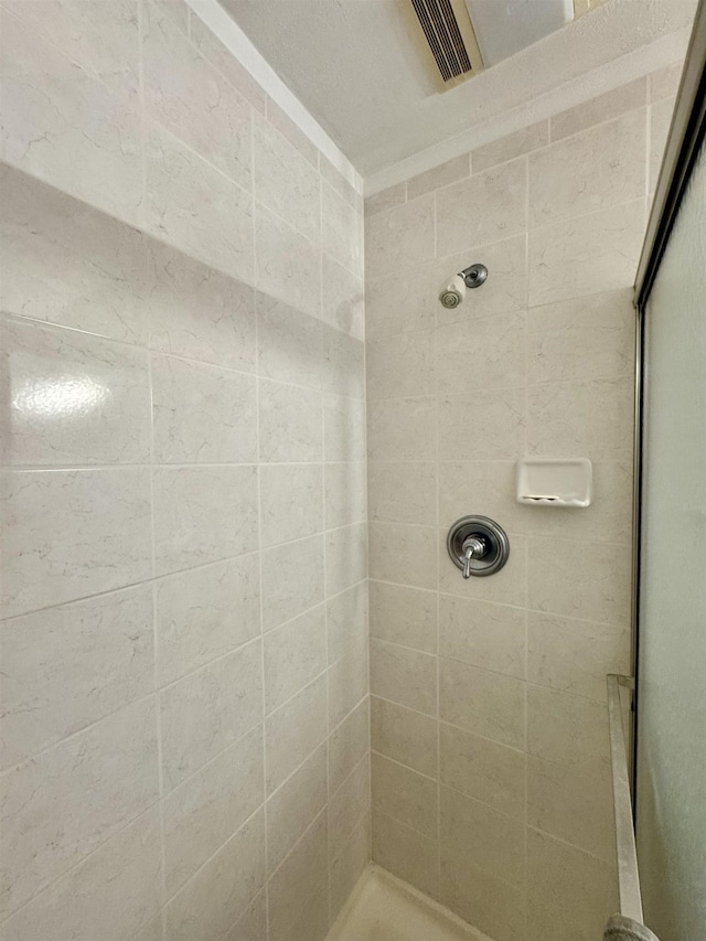 bathroom with visible vents and tiled shower