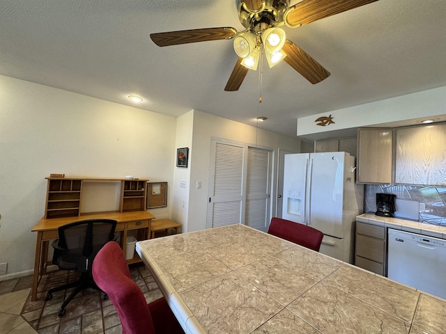 kitchen with ceiling fan, baseboards, white appliances, and tile counters