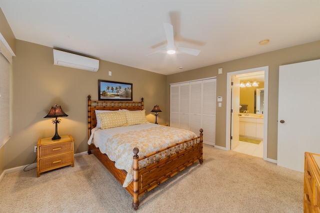 bedroom featuring ceiling fan, a closet, a wall mounted AC, ensuite bath, and light carpet