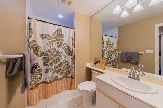 bathroom with toilet, large vanity, and tile floors