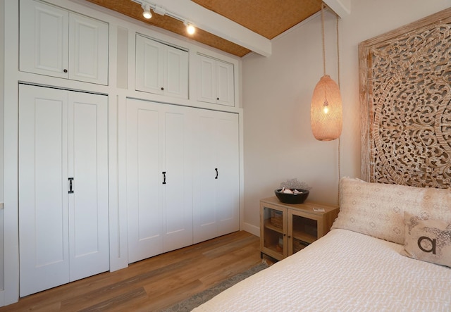 bedroom with dark wood-type flooring and rail lighting