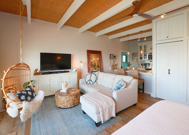 living room with light hardwood / wood-style floors and beamed ceiling