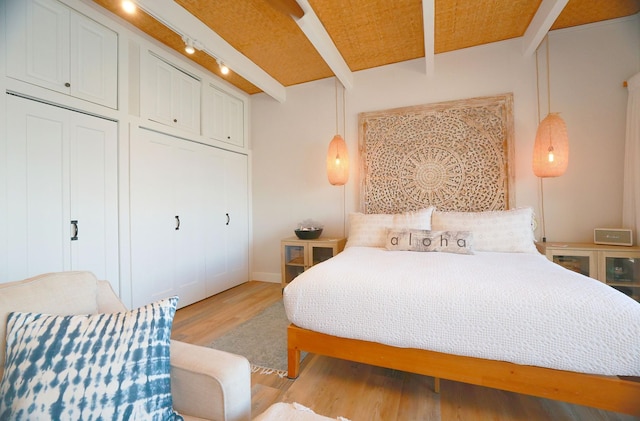 bedroom featuring beam ceiling and light hardwood / wood-style floors