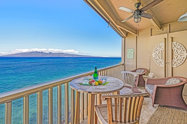 balcony featuring ceiling fan and a water and mountain view