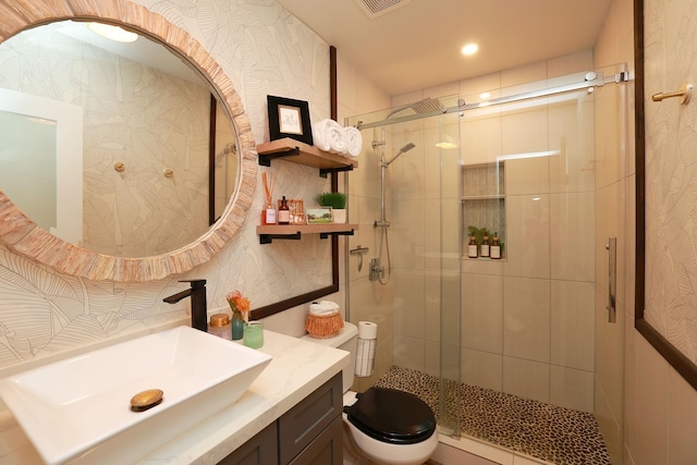 bathroom featuring an enclosed shower, vanity, and toilet