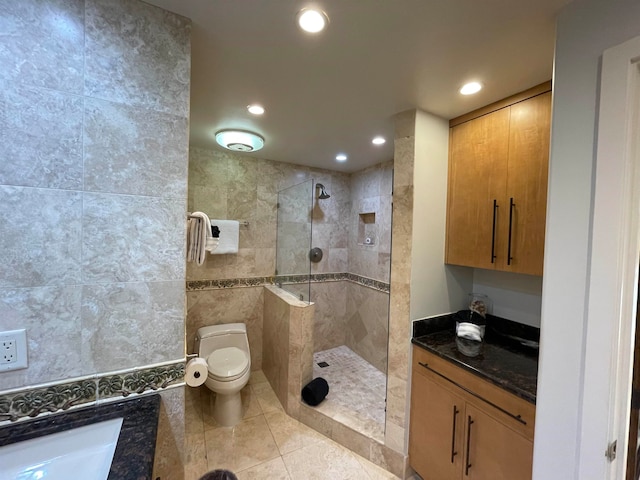 bathroom featuring tiled shower, tile walls, toilet, and tile patterned floors